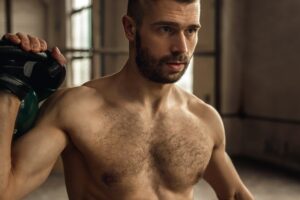 Shirtless male athlete with kettlebell